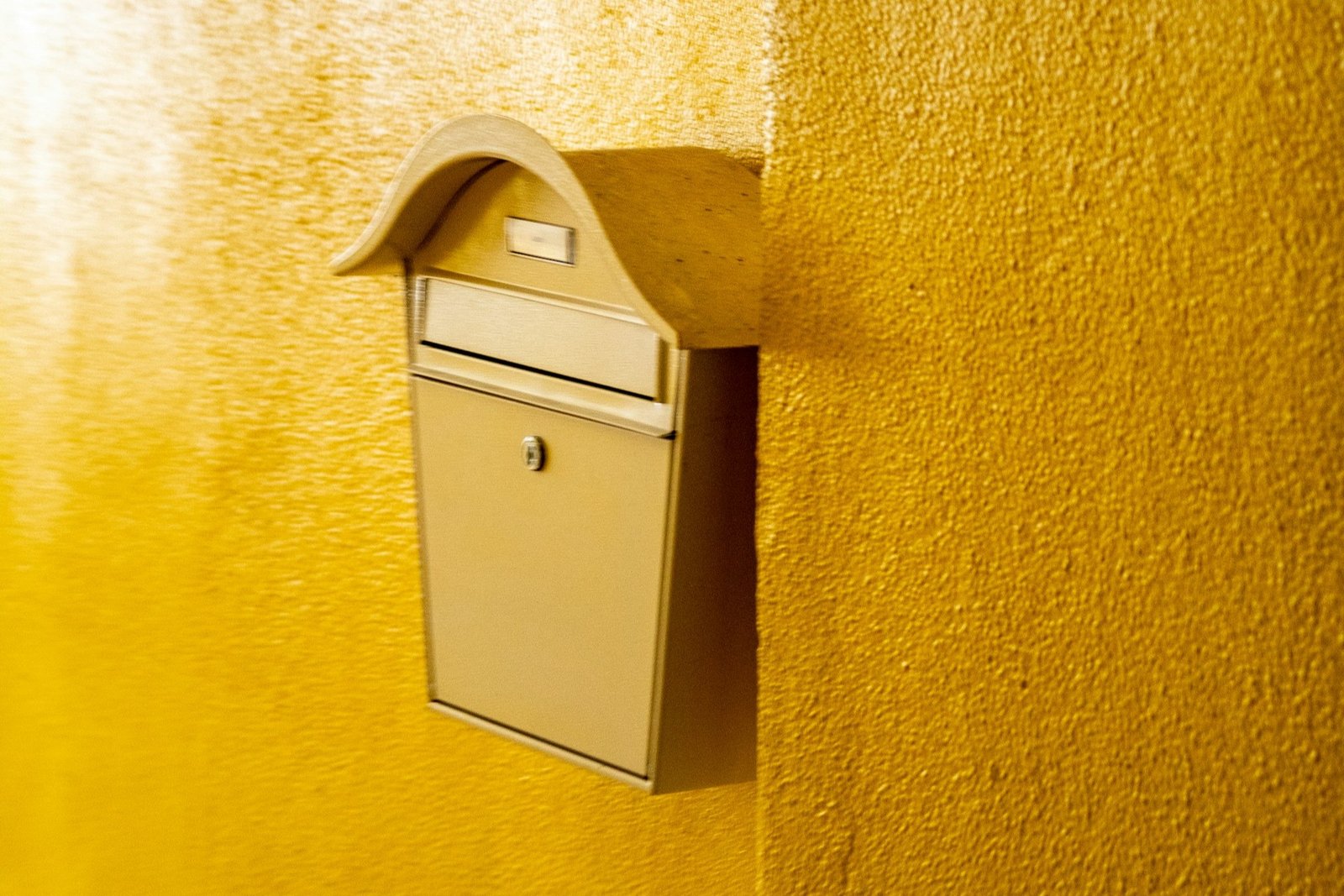 Nahaufnahme eines Briefkastenschlosses mit eingestecktem Schlüssel