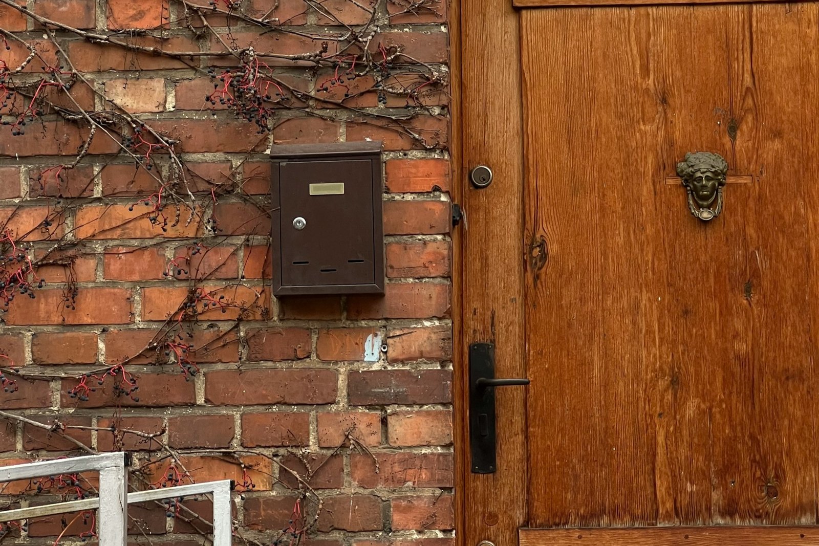 Schlüssel steckt im Briefkastenschloss und wird mit der Hand gehalten